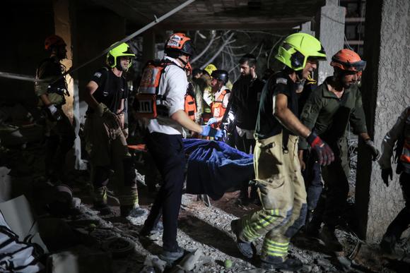 Des secouristes transportent un blessé, sur le site d’un impact de missile iranien, à Ramat Gan, en Israël, le 13 juin 2025.