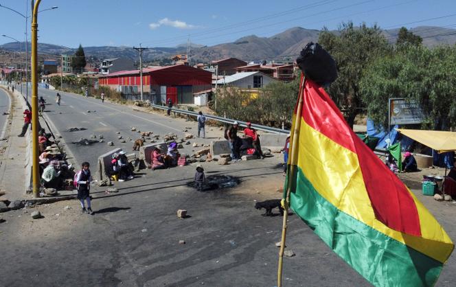 Photo capturée par un drone montrant un drapeau bolivien devant un barrage routier de partisans de l’ancien président bolivien Evo Morales, dans la ville de Sacaba, le 13 juin 2025.
