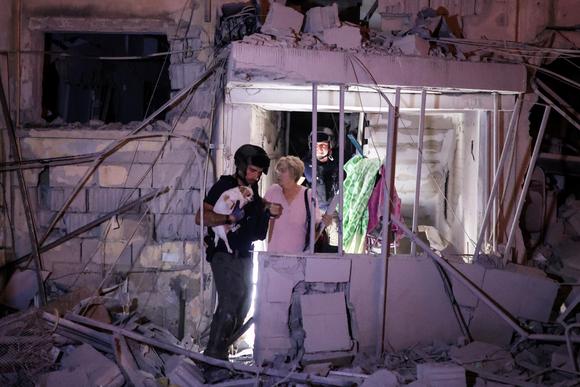 Une femme blessée évacuée avec son chien après le tir d’un missile iranien, dans le centre d’Israël, le 15 juin 2025.