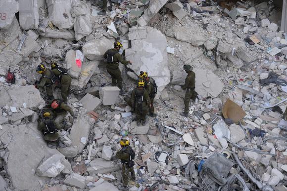 Des soldats israéliens fouillent les décombres à la recherche de personnes portées disparues dans une zone résidentielle touchée par un missile tiré d’Iran, près de Tel-Aviv, le 15 juin 2025.