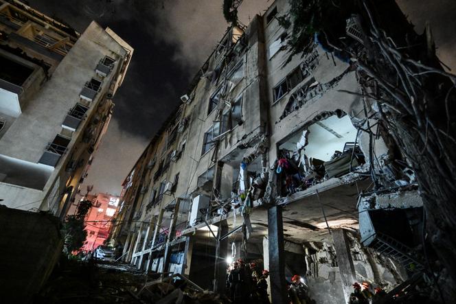 Des secouristes interviennent dans un immeuble touché par une frappe iranienne dans le centre d’Israël, le 15 juin 2025.