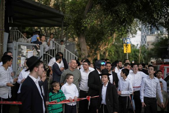 Des voisins observent les secouristes opérer sur un site frappé par un missile iranien, à Bnei Brak, près de Tel-Aviv, en Israël, le 16 juin 2025.