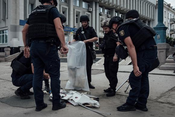 Ukrayna polisi, 16 Haziran 2025'te Sumy şehir merkezinde gerçekleşen çifte saldırının ardından Rus insansız hava aracından geriye kalan parçaları topluyor.