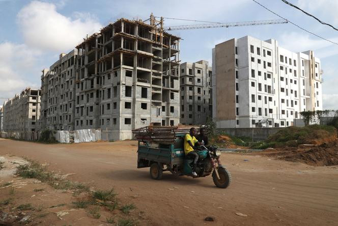 Devant un chantier de construction de nouveaux logements dans un quartier de Bingerville, près d’Abidjan, en Côte d’Ivoire, le 13 mars 2025.