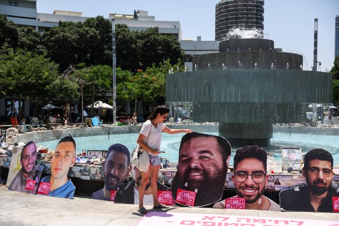 Les portraits d’otages israéliens retenus par le Hamas sont disposés autour d’une fontaine, à Tel-Aviv, le 18 juin 2025. 