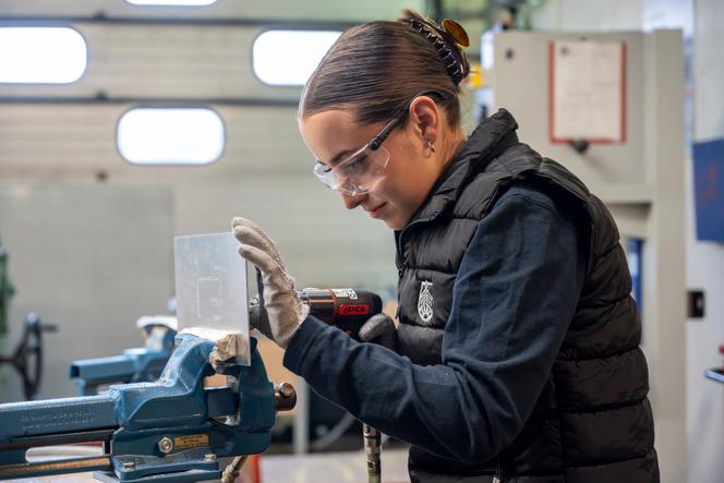 Um aprendiz trabalha em uma sala da Associação para o Treinamento em Negociação Aérea (AFMAÉ), reservada para o trabalho em materiais com folhas e materiais compostos. Em Bonneuil-en-France (Val-D'oise), 11 de junho de 2024.