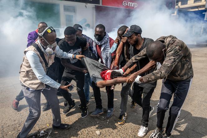 Des manifestants portent un homme gravement blessé alors qu’ils tentent de l’évacuer lors d’affrontements avec la police survenus au cours d’une manifestation contre la mort du blogueur Albert Ojwang, décédé en garde à vue, dans le centre de Nairobi, le 17 juin 2025.