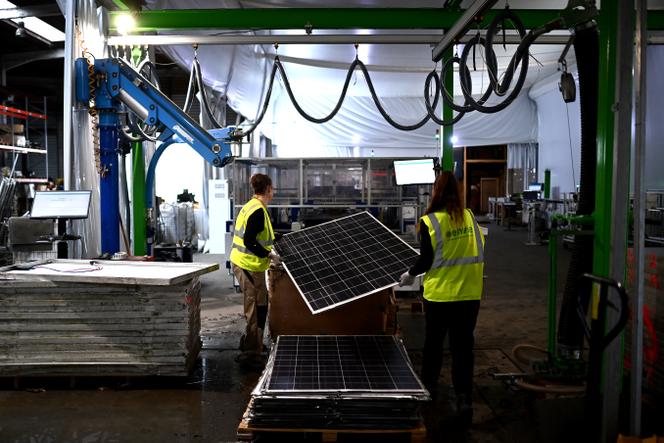 Os funcionários preparam um painel solar gasto antes de carregá-lo em uma máquina que permita sua desmantelamento para a reciclagem de peças, em Saint-Loubes (Gironde), 13 de novembro de 2023.