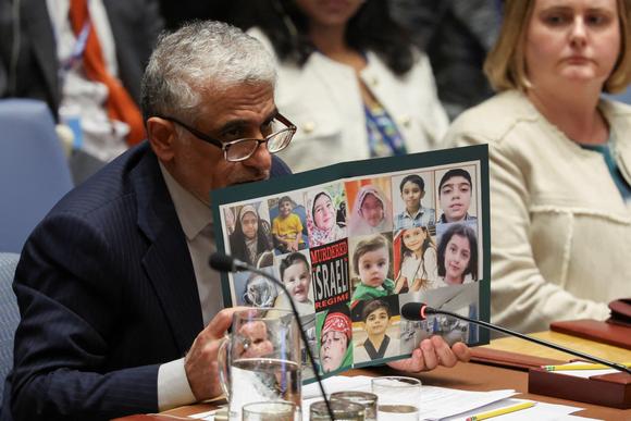 El embajador y representante permanente de Irán ante las Naciones Unidas, Amir Saeid Iravani, muestra fotos de personas que se cree que murieron por ataques aéreos israelíes durante una reunión del Consejo de Seguridad de la ONU sobre el conflicto entre Israel e Irán en la sede de la ONU en Nueva York, Estados Unidos, el 20 de junio de 2025.