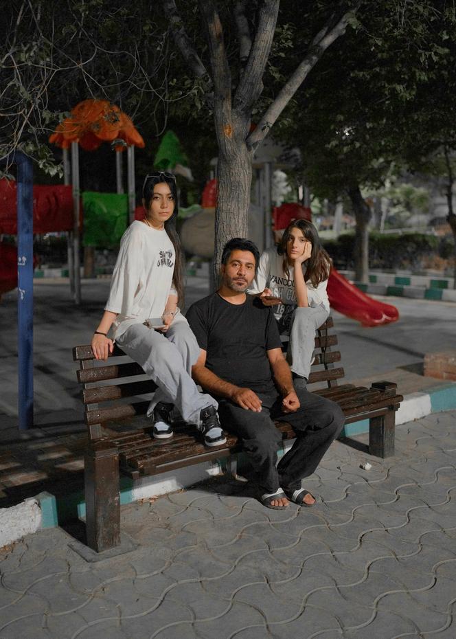 A gauche, Mohammad, sa fille et une amie. Ils se sont réfugiés dans le parc du quartier de Shahrara, une zone très touchées par les attaques israéliennes à Téhéran. Sa fille déclare : « Nous n’avons jamais connu la guerre auparavant, c’est notre première fois, c’est extrêmement stressant. » Ils affirment que ce quartier est connu pour abriter un grand nombre de scientifiques dans le domaine du nucléaire, ce qui en fait une cible potentielle. Ils ont décidé de quitter ce parc et d’aller dans un quartier où ils seraient plus en sécurité. A Téhéran, le 14 juin 2025.