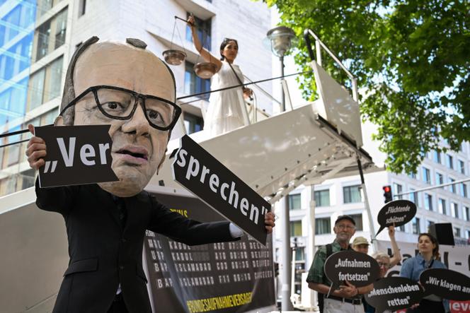 Un manifestant représentant le chancelier Friedrich Merz brise une pancarte sur laquelle est inscrit « promesse » lors d’une manifestation pour la poursuite de la délivrance de visas aux Afghans vulnérables, à Berlin, le 20 juin 2025.