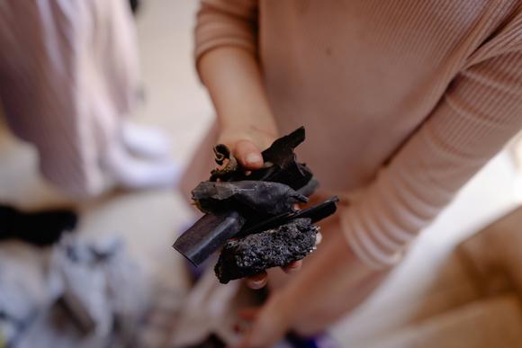 Une jeune fille montre les débris d'un missile tombé quelques jours plus tôt, à Haïfa, en Israël, le 20 juin 2025.