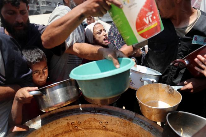 Des Palestiniens attendent de recevoir de la nourriture préparée par une cuisine caritative, à Gaza, le 21 juin 2025.