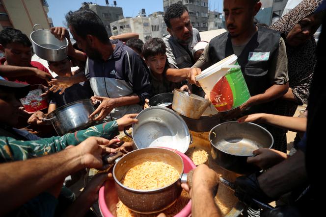 Des Palestiniens attendent de recevoir de la nourriture préparée par une cuisine caritative, à Gaza, le 21 juin 2025.