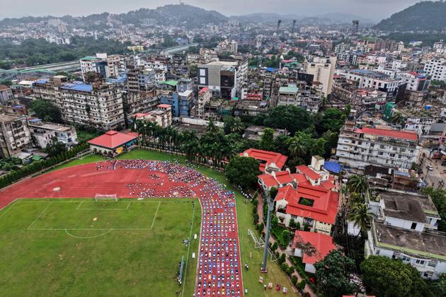 People practice yoga at a sports field in Guwahati, India, on June 21, 2025.