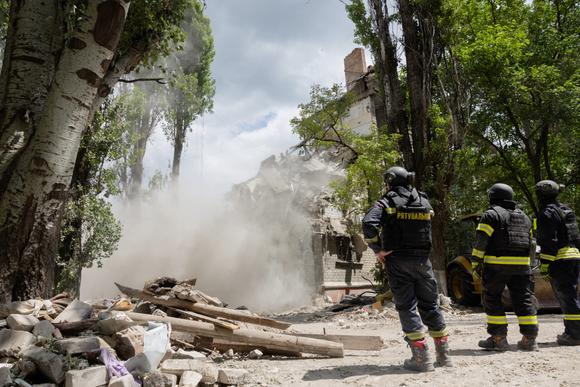 Reddingswerkers staan voor een gebouw dat is beschadigd door een Russische aanval, in Kramatorsk, Oekraïne, 22 juni 2025.