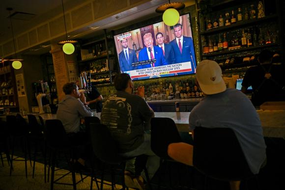 Les clients d’un bar regardent Donald Trump prononcer un discours à la nation, après les frappes américaines sur les installations nucléaires iraniennes, à Chicago (Illinois), le 21 juin 2025.