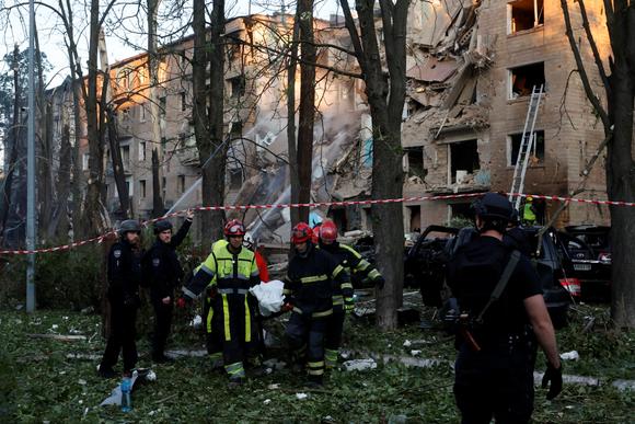 Reddingswerkers halen een lichaam uit een woongebouw in Kiev dat is getroffen door Russische aanvallen, 23 juni 2025.