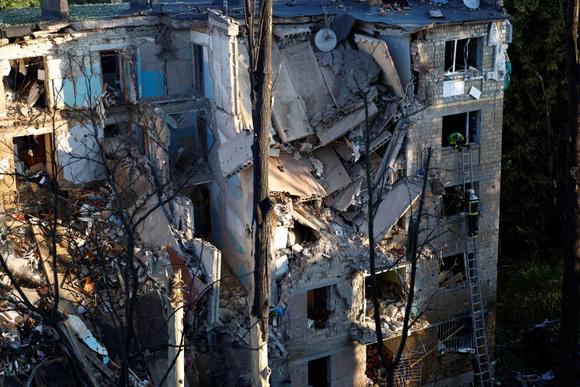 Brandweerlieden op de locatie van een woongebouw dat werd getroffen tijdens Russische aanvallen op Kiev, 23 juni 2025.