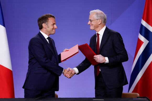 Le président français, Emmanuel Macron (à gauche), et le premier ministre norvégien, Jonas Gahr Store, se serrent la main, au Musée national d’Oslo, en Norvège, le 23 juin 2025.