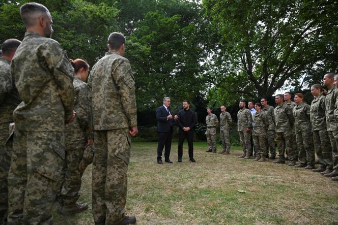 Britain's Prime Minister Keir Starmer and Ukraine's President Volodymyr Zelensky meet with British and Ukrainian troops from Operation Interflex in the garden of 10 Downing Street, central London, on June 23, 2025.