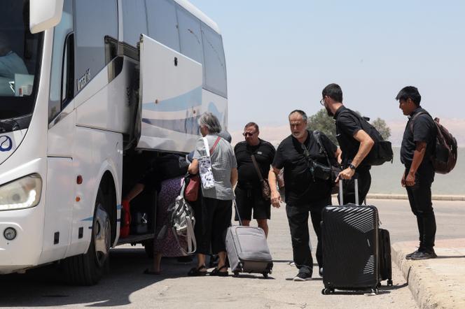 Des expatriés, dont des diplomates de différentes nationalités, bloqués en Cisjordanie et en Israël, lors de leur évacuation par le pont du roi Hussein, à South Shuna, en Jordanie, le 19 juin 2025. 