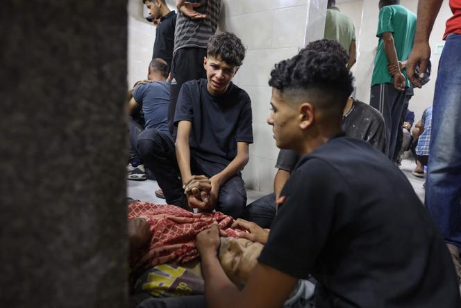 Devant le corps d’un parent tué par des tirs israéliens au point de distribution de l’aide alimentaire mis en place par la Gaza Humanitarian Foundation (GHF), à l’hôpital Al-Awda, dans le camp de réfugiés de Nousseirat, dans le centre de la bande de Gaza, le 24 juin 2025.