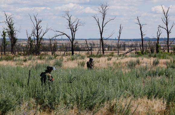 Des sapeurs-miniers russes déminent une zone au bord d’une autoroute, dans la région de Donetsk, en Ukraine, le 24 juin 2025.