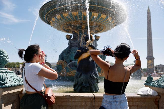 Des personnes se rafraîchissent dans une fontaine de la place de la Concorde, à Paris, le 21 juin 2025.