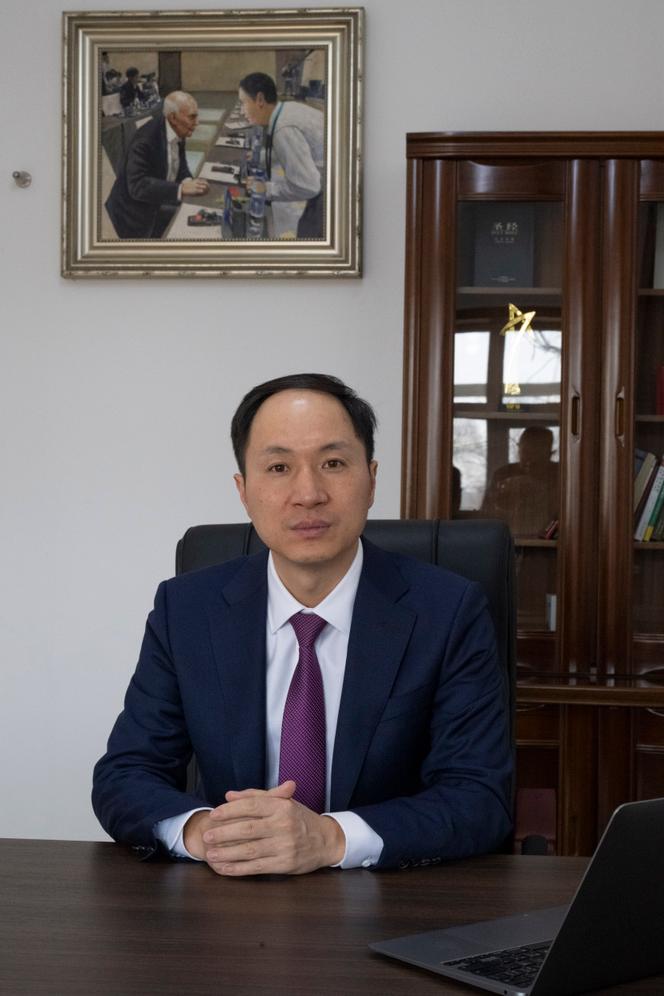 Le docteur He Jiankui, à son bureau, où une peinture le représente face au prix Nobel de médecine James Watson, codécouvreur de la structure en double hélice de l’ADN, à Pékin, le 26 février 2025.