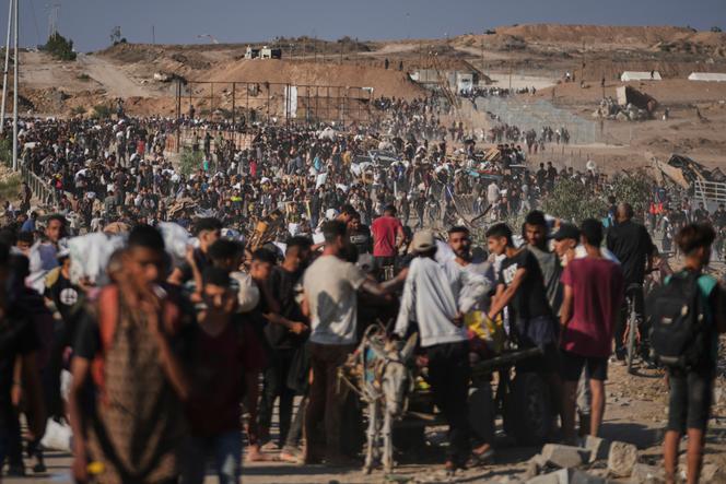 Des Palestiniens transportent des paquets d’aide humanitaire distribués par la Gaza Humanitarian Foundation, organisation américaine, à Khan Younès, dans le sud de la bande de Gaza, le jeudi 26 juin 2025.