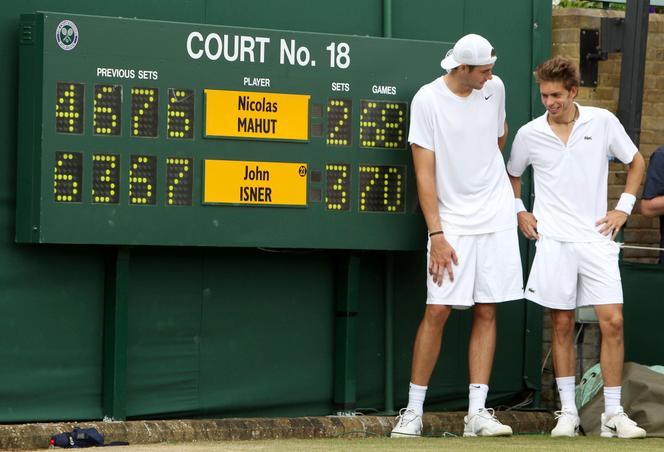 John Isner (à gauche) et Nicolas Mahut, à côté du tableau d’affichage du court numéro 18 du tournoi de tennis de Wimbledon, le 24 juin 2010, à Londres.