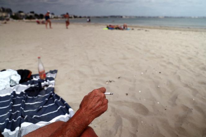 A vacationer smokes a cigarette on the Baule beach (Loire-Atlantique), on June 25, 2025. ban smoking parks, beach near