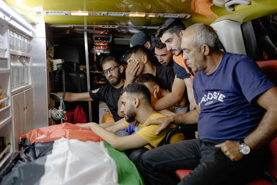 Palestinians stand by the body of their friend killed during an Israeli settler attack, outside Ramallah hospital, West Bank, June 25, 2025.