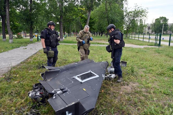 Des experts en explosifs et des policiers ukrainiens examinent des éléments d’un drone Shahed 136 après une attaque aérienne russe à Kharkiv, dans l’est de l’Ukraine, le 4 juin 2025.