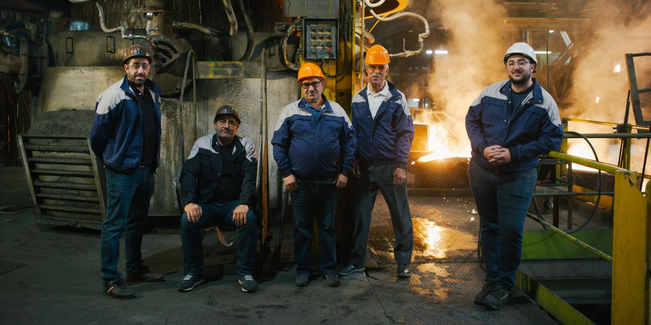 Devant le cubilot, dans l’usine Stellantis de Sept-Fons, de gauche à droite : Nicolas Penela, responsable d’unité ; François Penela, 49 ans, responsable de la fonderie ; Antonio Penela, 70 ans, retraité et son beau-frère Joaquim Lelo, retraité ; et Anthony Penela, 24 ans, responsable logistique. À Dompierre-sur-Besbre (Allier), le 19 mai 2025.
