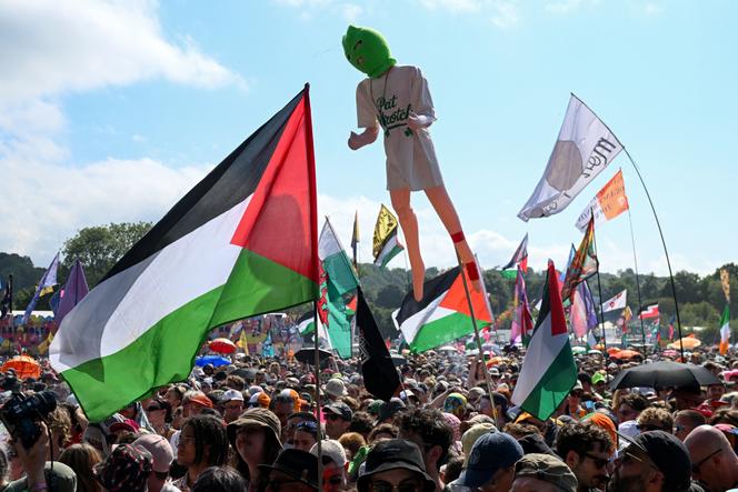 Des festivaliers brandissent des drapeaux palestiniens, lors du concert de Kneecap au Festival de Glastonbury, le 28 juin 2025. 
