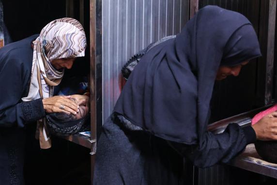 Des femmes pleurent les corps de leurs proches tués lors des frappes israéliennes de la nuit, à la morgue de l’hôpital Al-Shifa, dans le centre de la bande de Gaza, le 28 juin 2025.