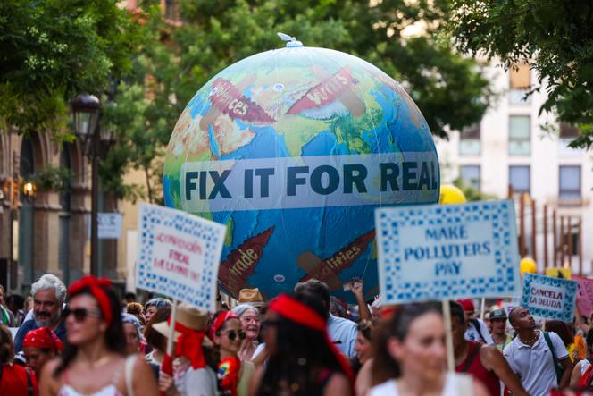 Des personnes participent à une marche exigeant un cadre de résolution de la dette souveraine sous l’égide de l’ONU, à la veille de la quatrième Conférence internationale sur le financement du développement, à Séville, le 29 juin 2025.