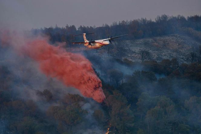 A DASH firefighting aircaft drops fire retardant during a wildfire near Bizanet, southwest France, on June 29, 2025. 