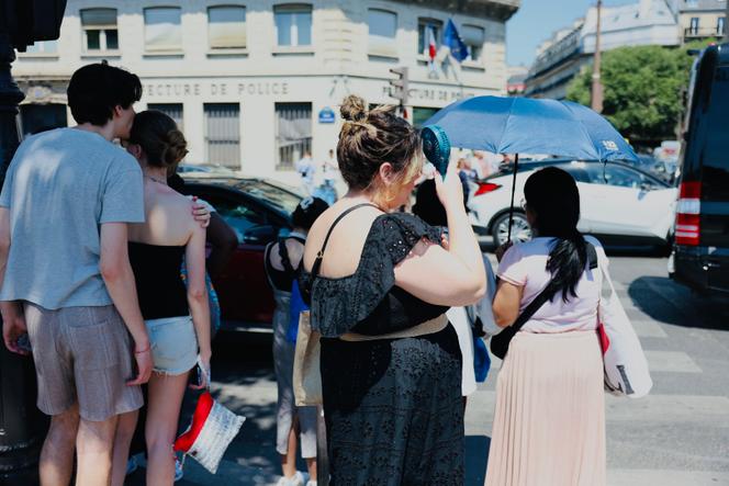 Une femme utilise un ventilateur portable, à Paris, le 30 juin 2025.