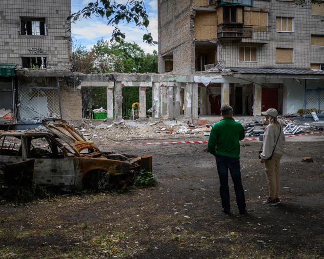 Des passants regardent un immeuble touché par un missile russe dans la nuit du 16 au 17 juin 2025 dans le raïon Chevtchenkivsky, dans l’ouest de la capitale ukrainienne, Kiev, le 29 juin 2025.