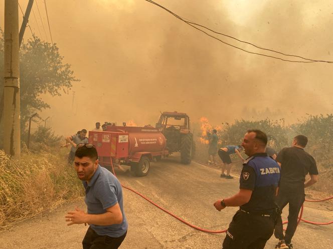 Des pompiers et des habitants interviennent sur un incendie de forêt dans le district de Menderes, de la ville d’Izmir (Turquie), le 29 juin 2025.