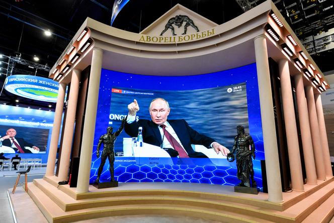 Le président russe Vladimir Poutine, retransmit sur un écran du centre de congrès et d’exposition ExpoForum, pendant la session plénière du Forum économique international de Saint-Pétersbourg (SPIEF), le 20 juin 2025.