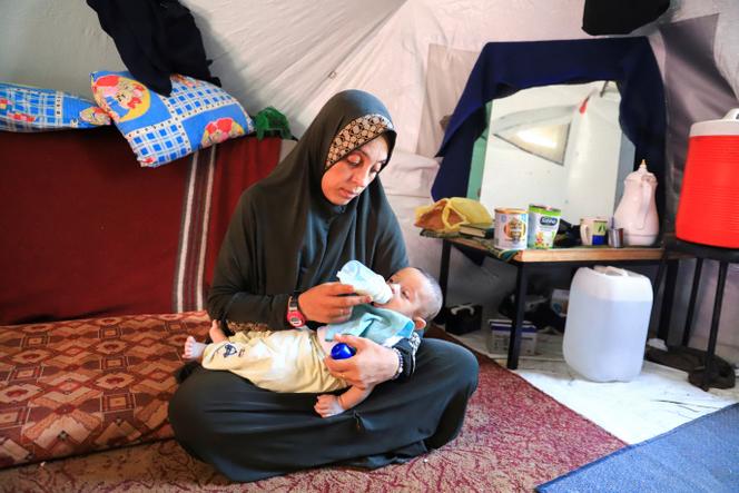 Une Palestinienne avec l’un de ses jumeaux de deux mois, alors qu’elle lutte pour trouver du lait maternisé dans un contexte de pénurie persistante, à Gaza, le 25 juin 2025.