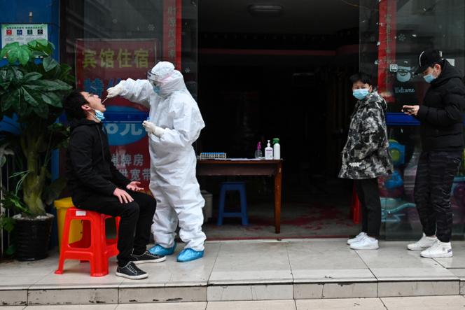 Un soignant prélève un échantillon sur une personne pour un test de dépistage du Covid-19, à Wuhan, en Chine, le 29 mars 2020.