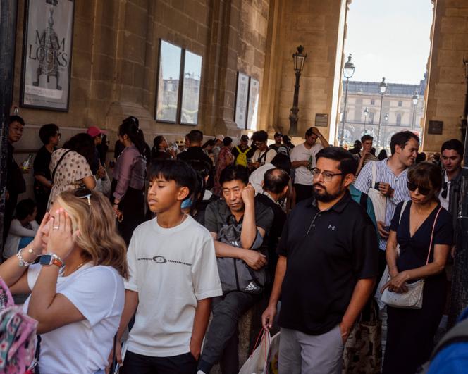 Des touristes, à l'ombre du passage entre la place du Louvre et le Palais-Royal, à Paris, le 30 juin 2025.