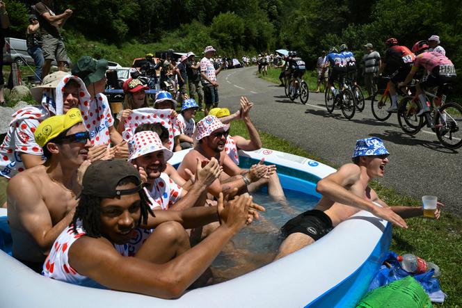 Os espectadores usam as cores da camisa da bolinha do melhor alpinista, patrocinadas por uma grande marca de distribuição, na passagem dos corredores do turismo, na estrada para o Col d'Agnés (Ariège), em 14 de julho de 2024.