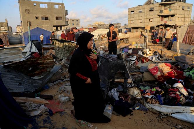 Os palestinos inspecionam os danos após um bombardeio israelense em tendas que abrigavam pessoas deslocadas em Khan Younès, no sul da Faixa de Gaza, em 2 de julho de 2025.