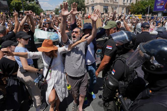 Oficiais sérvios da gênese sérvia levantam um obstáculo após uma manifestação maciça em Belgrado, em 30 de junho de 2025. 